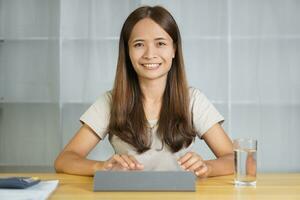 Asian woman working at home through computer photo