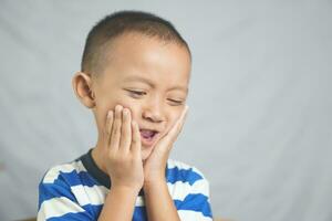 A boy has a toothache from gingivitis photo