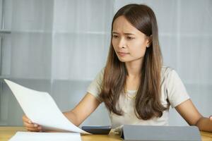 Asian woman working at home Got stressed after looking at documents photo