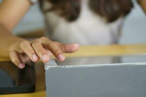 Asian woman working at home Use your hand to touch the computer screen. photo