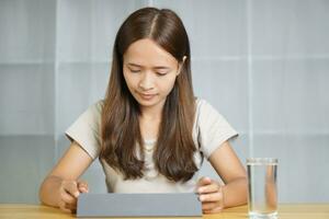 Asian woman working at home through computer photo