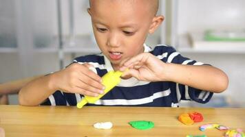 Boy making plasticine to promote development on the table in the house. video