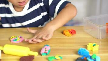 Boy making plasticine to promote development on the table in the house. video