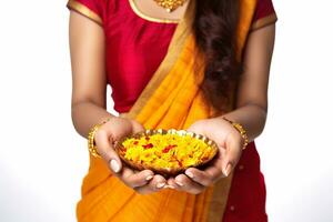 A photo of a beautiful mature indian woman holding marigold flowers in a plate while celebrating the festival of lights, ai generative