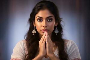 A photo of a beautiful indian woman with her hands folded in prayer in front of the camera, ai generative