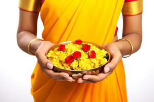 A photo of a beautiful mature indian woman holding marigold flowers in a plate while celebrating the festival of lights, ai generative