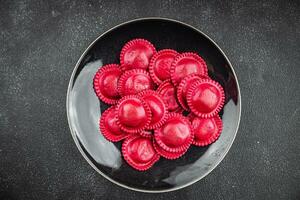 beet ravioli red color meat filling smoked ham Cooking appetizer meal food snack on the table photo