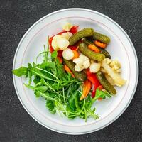 vegetables pickled salad spicy cucumber, gherkin, carrot, onion, cauliflower, pepper appetizer meal food snack on the table copy space food background rustic top view photo