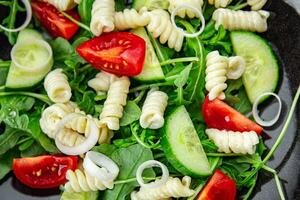 pasta ensalada fusilli pasta, pepino, tomate, verde lechuga, cebolla delicioso sano comiendo Cocinando aperitivo comida comida bocadillo en el mesa Copiar espacio comida antecedentes foto