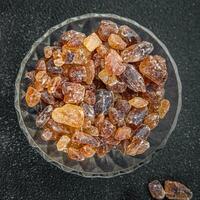 cane sugar rock sugar crystals pieces candy brown sugar candied sugar big rock caramel eating appetizer meal food snack on the table copy space food background rustic top view photo