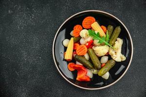 salad vegetable pickled tasty spicy cucumber, gherkin, carrot, onion, cauliflower, pepper appetizer meal food snack on the table copy space food background rustic top view photo