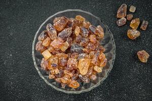 cane sugar crystal rock pieces candy brown sugar candied big rock caramel crystals sugar  taste eating cooking appetizer meal food snack on the table copy space food background rustic top view photo