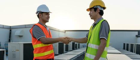 Engineers team shake hand after install air condition systems on site. Contractor and inspector inspection construction during project. civil Forman check quality assurance control. Audit, inspect photo