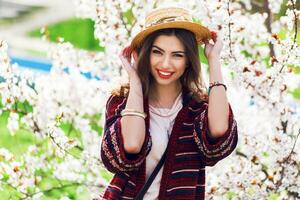 Sunny spring  portrait of happy young woman laughing and posing near flower tree. photo