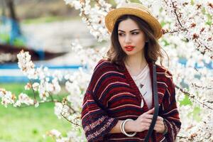 Sunny spring  portrait of happy young woman laughing and posing near flower tree. photo