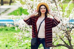 Sunny spring  portrait of happy young woman laughing and posing near flower tree. photo