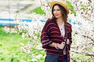 Sunny spring  portrait of happy young woman laughing and posing near flower tree. photo