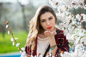 Sunny spring  portrait of happy young woman laughing and posing near flower tree. photo