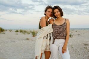 verano Moda imagen de dos morena europeo mujer en lino ropa posando en el playa foto