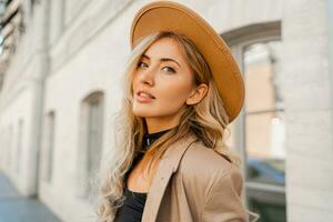 Close up  outdoor  portrait  of stylish blond woman with perfect wavy hairs in beige hat and casual suit. Full lenght. photo