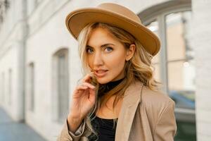 Close up  outdoor  portrait  of stylish blond woman with perfect wavy hairs in beige hat and casual suit. Full lenght. photo