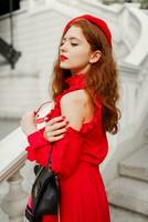 Blissful woman with perfect smile laughing and walking in Paris. Ginger girl in red  beret and dress with close eyes. photo