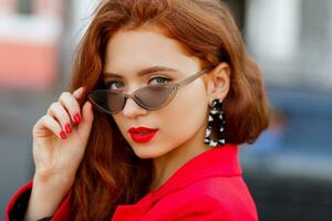 Pretty  woman in red jacket posing outdoor. photo