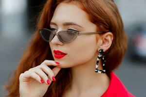 Pretty  woman in red jacket posing outdoor. photo