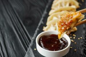 delicious fried gyoza dumplings on a black plate photo