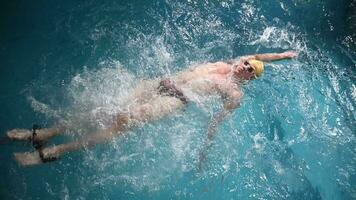 submarino ver de profesional nadador formación en nadando piscina, 4k 120 fps súper lento movimiento crudo video. triatleta nadar en negro traje de neopreno video