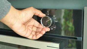 hand setting temperature control on oven. video