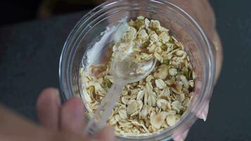 top view of spoon pick granola Musli from a plastic container video