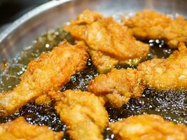 close - up of chicken wings on a frying pan photo