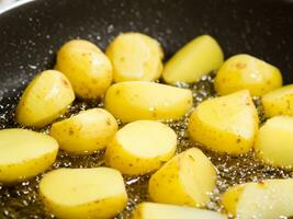 fried potatoes with oil in frying pan photo