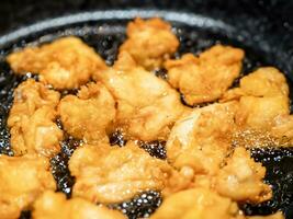 close - up of chicken wings on a frying pan photo