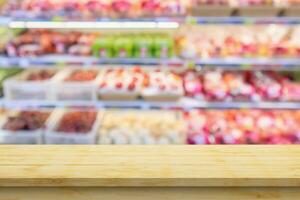 Empty wood table top with supermarket blurred background for product display photo