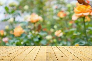 Empty wood table top with blur rose garden background for product display photo