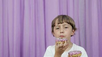 un joven chico es comiendo un rosquilla con asperja video