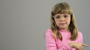 un pequeño niña en lentes señalando a alguna cosa video