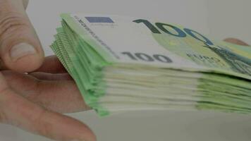 une main en portant une empiler de 100 euro billets de banque video