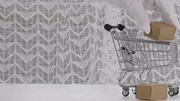 a person in white gloves holding a box in a shopping cart video