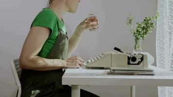 a woman is sitting at a desk with a laptop and a plant video