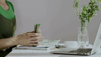 a woman is sitting at a desk with a laptop and a plant video