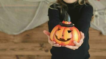 a little girl in a witch hat holding a pumpkin video