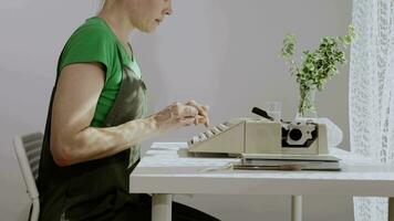 a woman is sitting at a desk with a laptop and a plant video