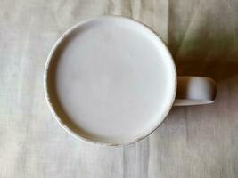 White tea mug was lying on the table photo
