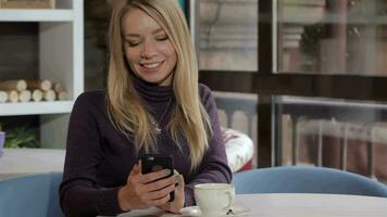 Woman messages by her cellphone at the cafe video