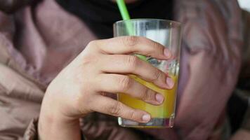 mano de mujer sosteniendo un vaso de jugo de naranja video