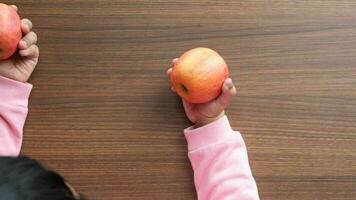 child hand pick a apple on table video