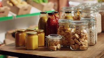 Close up on bulk food items in reusable glass jars used by environmentally friendly supermarket to lower climate impact. Local shop pantry staples in biodegradable nonpolluting packaging, panning shot video